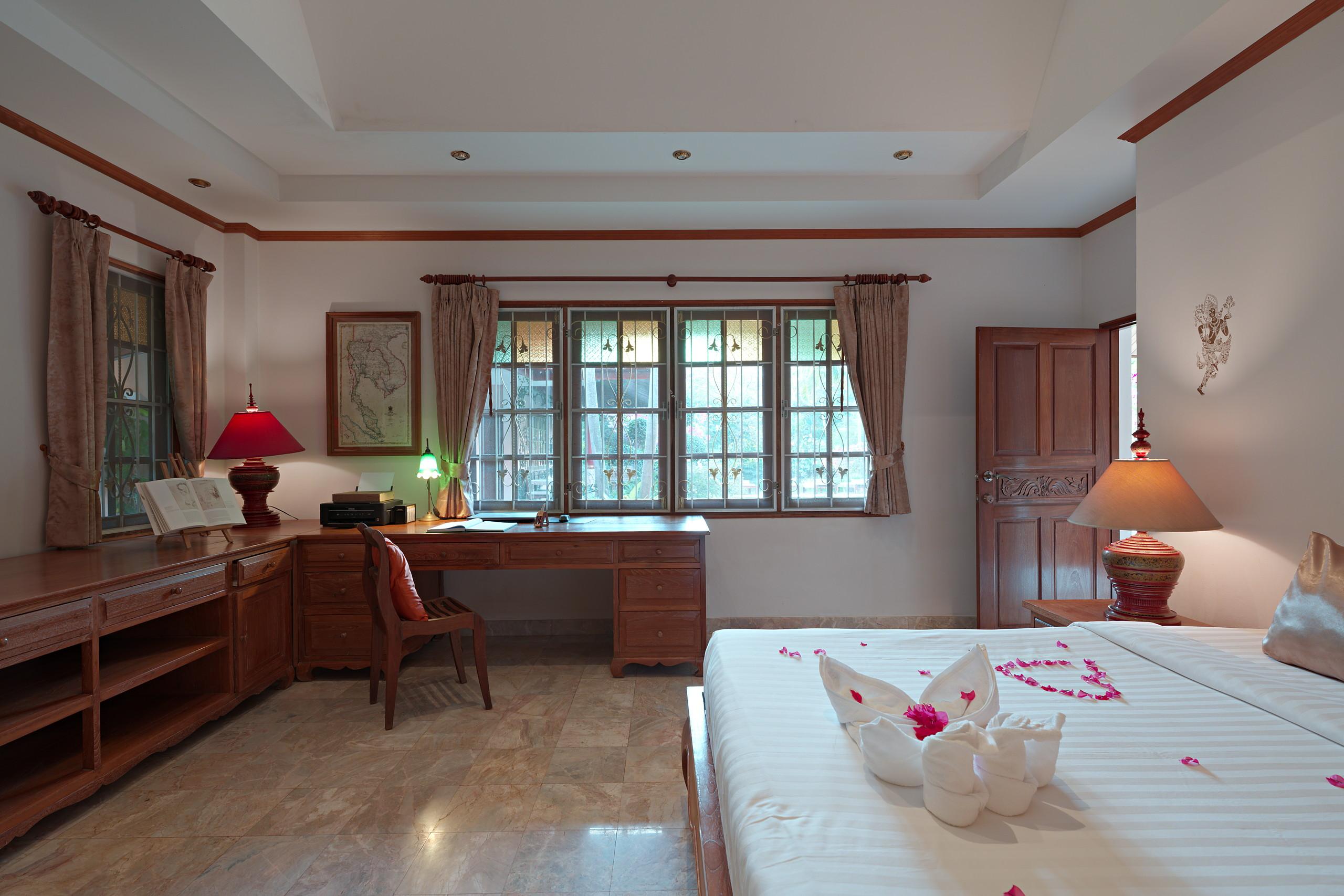 Schlafzimmer mit Schreibtisch und Fenster zum Garten