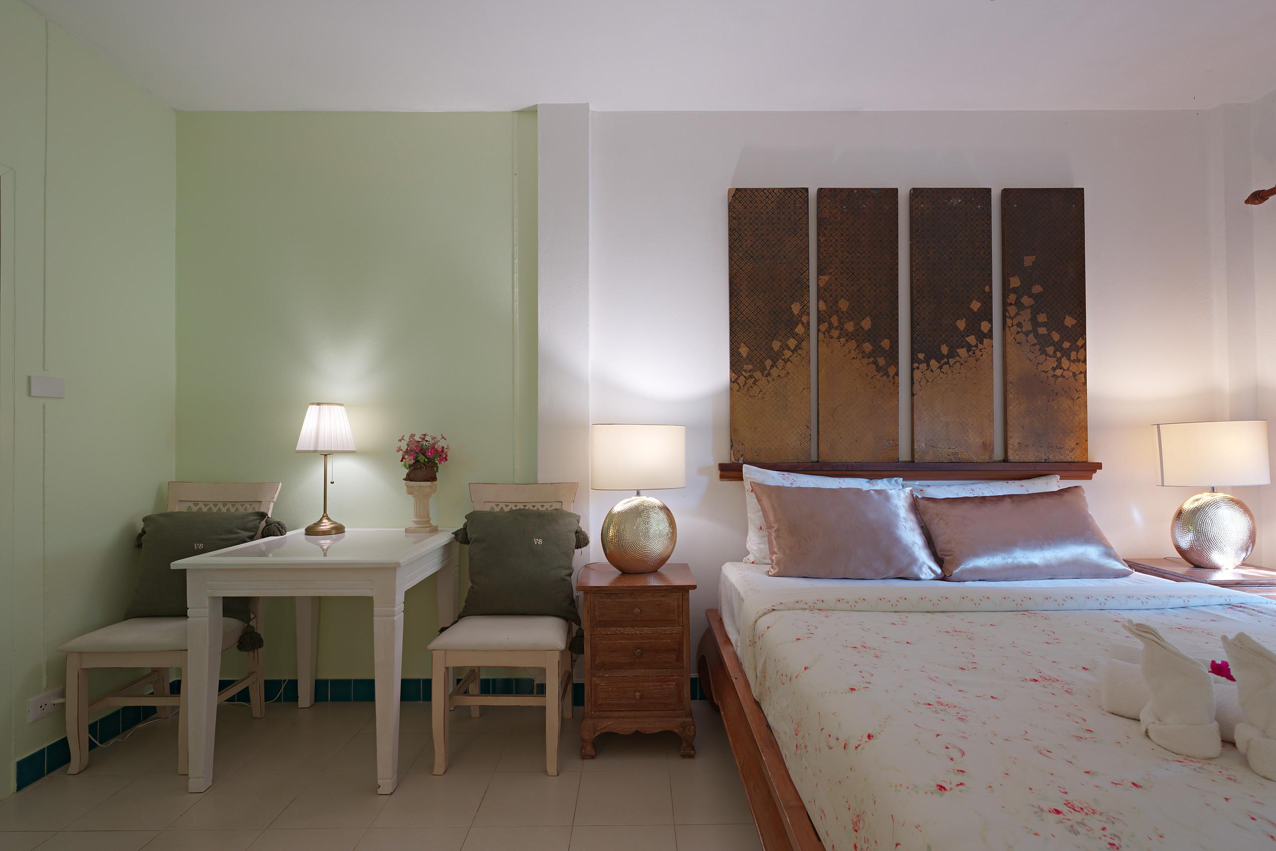 Schlafzimmer mit salbeigrünen Wänden und goldenem Kopfteil