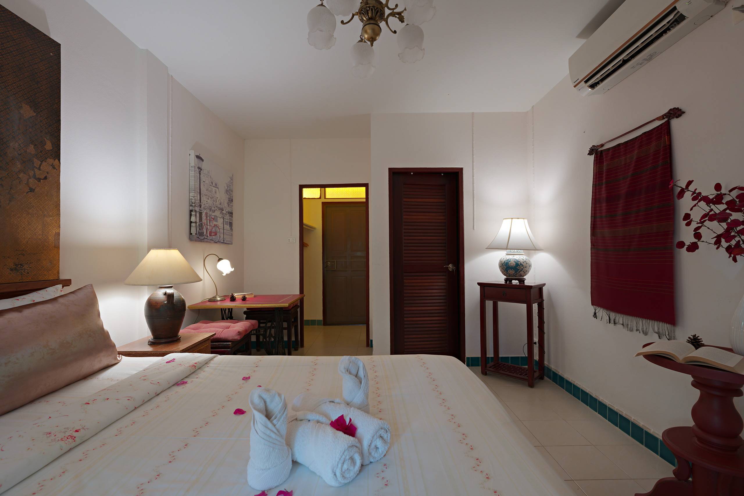 Schlafzimmer mit Handtuchschwänen und Nachttischlampen
