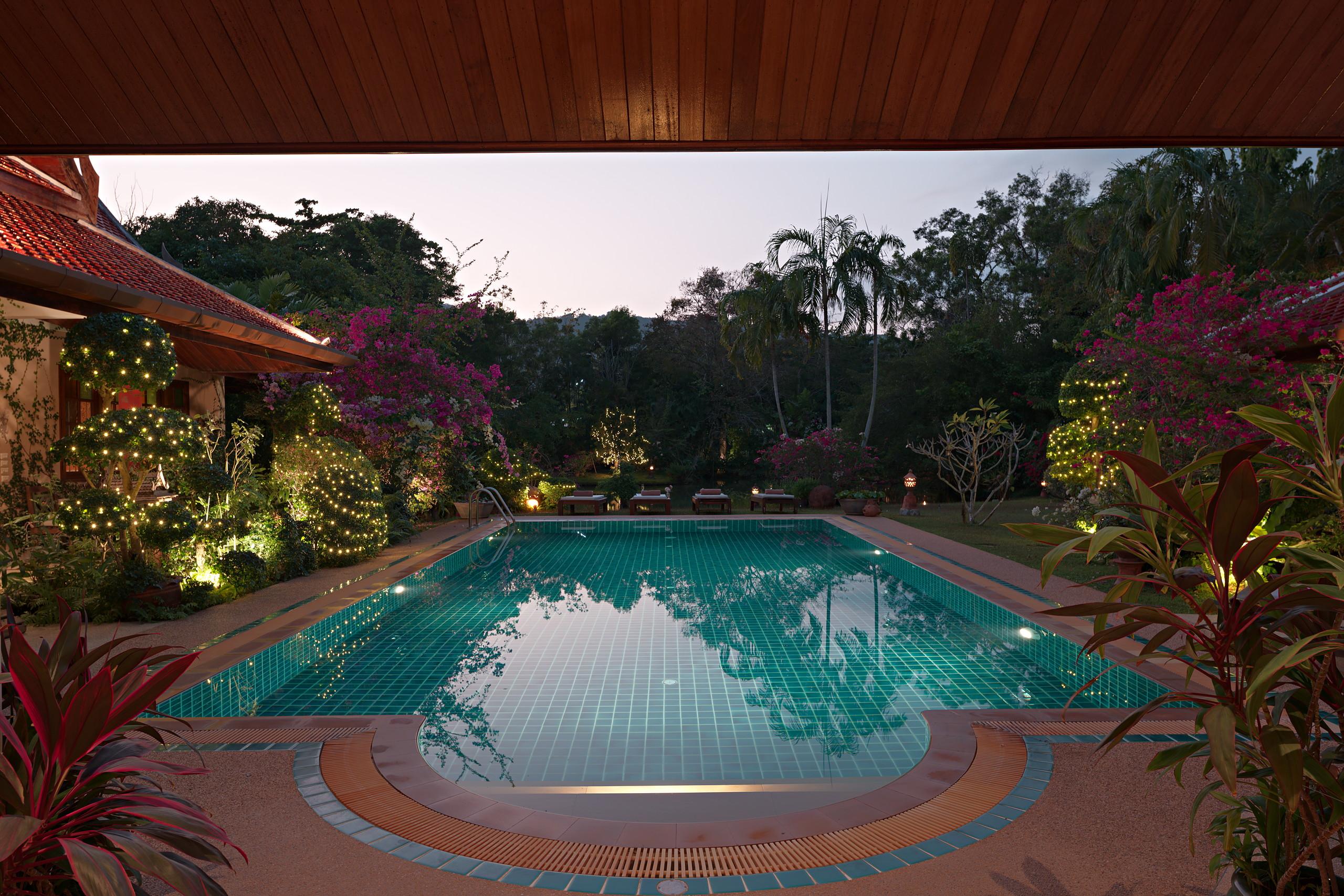 The pool seen from the living pavilion, framed by teak columns