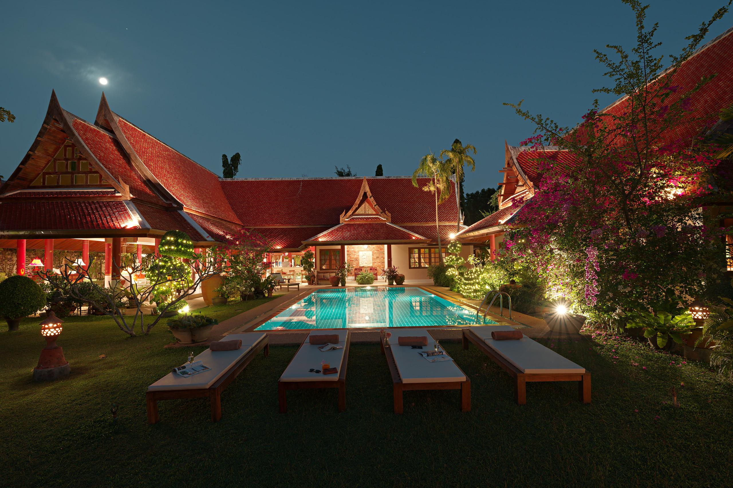 Evening view across the lawn to the pool terrace and sun loungers
